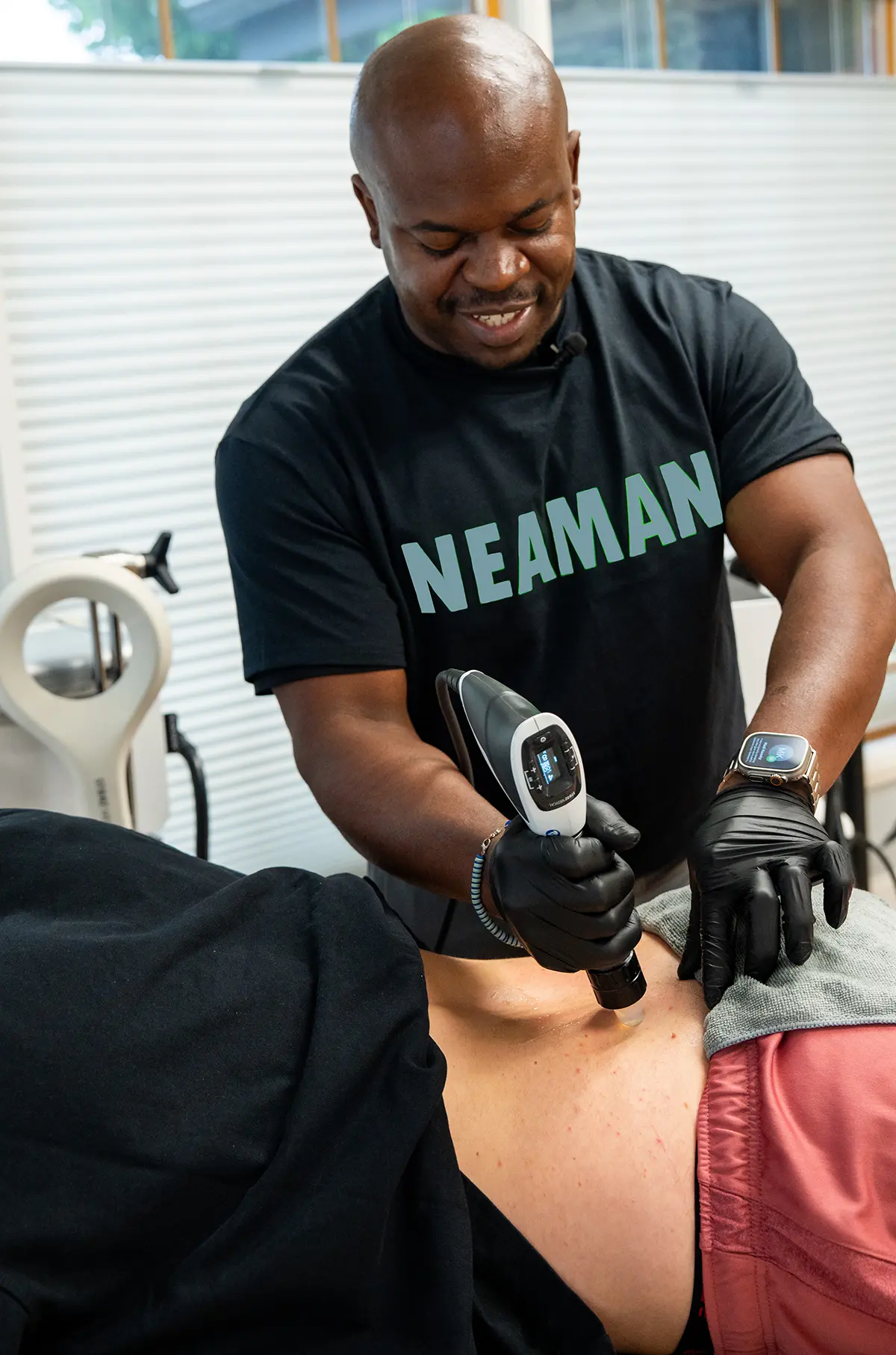 doctor providing shockwave therapy to someones backside